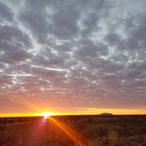 Sun rising to the left of Uluru